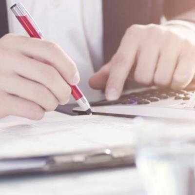 Jemand kalkuliert etwas an einem Schreibtisch